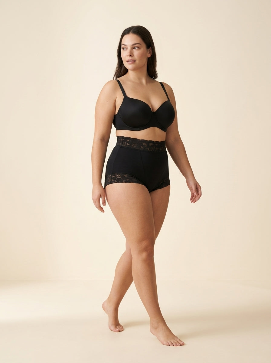 Editorial model wearing black everyday smoothing shapewear against a warm ivory studio backdrop — Everyday Smoothing